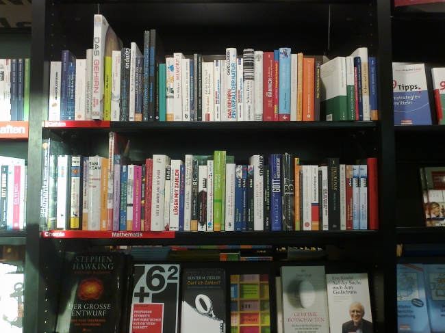 Gehirn und Verhaltensforschung, Buchregal in der Mayer'schen, u.a. "Lügen mit Zahlen", "Das Gehirn - Ein Unfall der Natur", "Kandel: Auf der Suche nach dem Gedächtnis"
