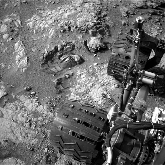 View From Camera Not Used During Curiosity's First Six Months on Mars, This view of Curiosity's left-front and left-center wheels and of marks made by wheels on the ground in the "Yellowknife Bay" area comes from one of six came...
