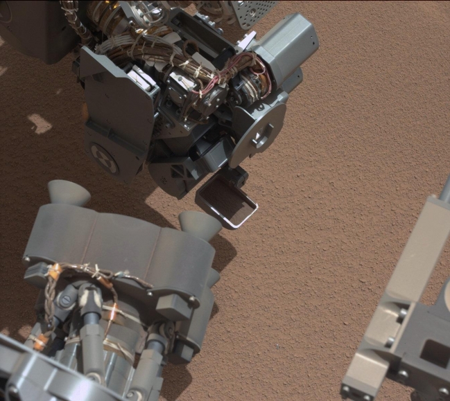 View of Curiosity's First Scoop Also Shows Bright Object,  This image from the right Mast Camera (Mastcam) of NASA's Mars rover Curiosity shows a scoop full of sand and dust lifted by the rover's first use of the sc...