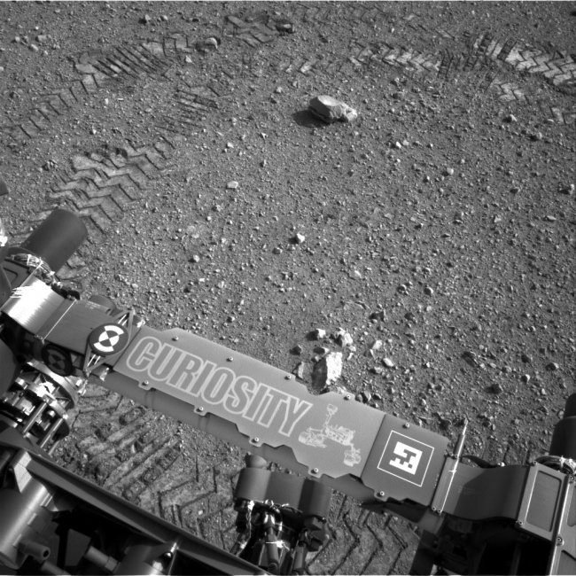 Curiosity Leaves Its Mark, This image shows a close-up of track marks from the first test drive of NASA's Curiosity rover. The rover's arm is visible in the foreground. A close inspect...