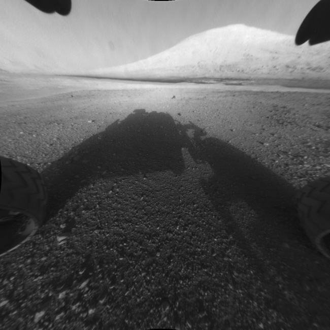 Behold Mount Sharp!,  This image taken by NASA's Curiosity shows what lies ahead for the rover -- its main science target, Mount Sharp. The rover's shadow can be seen in the fore...