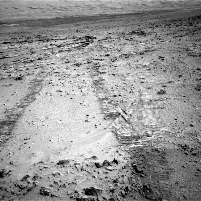 First Leg of Long Trek Toward Mount Sharp, This view from the left Navigation Camera (Navcam) of NASA's Mars Rover Curiosity looks back at wheel tracks made during the first drive away from the last s...