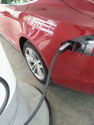 Roter Tesla beim Laden