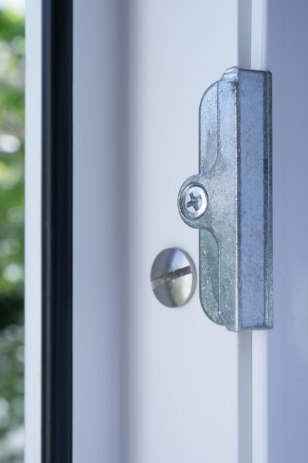 Window lock close-up, Close-up of a silver lock bracket as it can be found on a modern window frame, illustrating safety features of a modern home, security measures