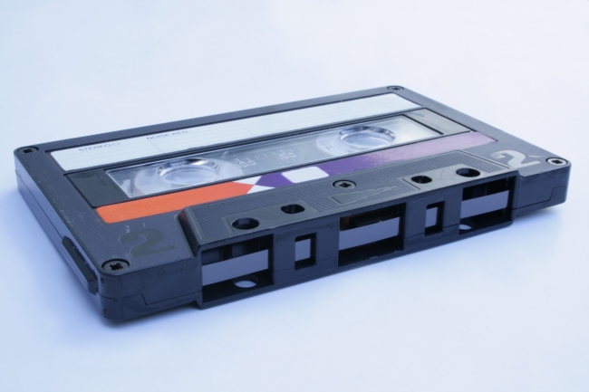 80s audio cassette, horizontal, An 1980s style tape audio cassette as it was sold in asian markets. Used condition with marks and scratches. In horizontal position on white background, show...