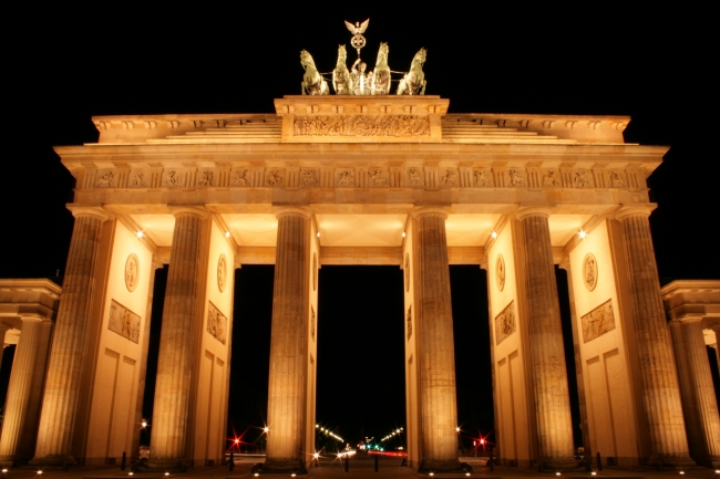 Brandenburg Gate in Berlin at Night, Brandenburger Tor in Berlin at night against a black sky, seen from Unter den Linden, showing the Troika. Symmetrical view focusing on the center part.