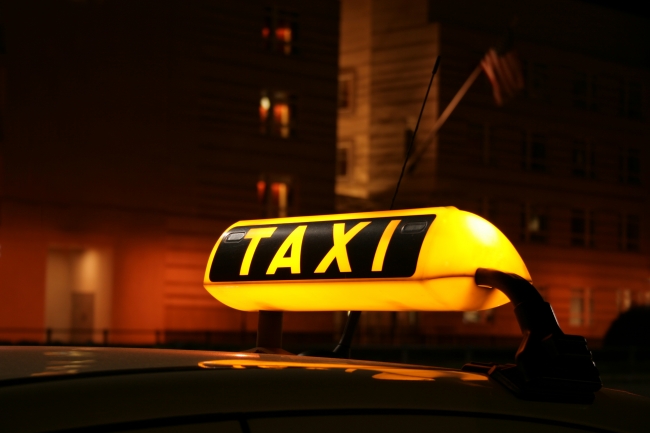 Illuminated Taxi sign, Illuminated TAXI sign on car cab waiting for a fare in the city at night, seen in front of the Berlin US Embassy