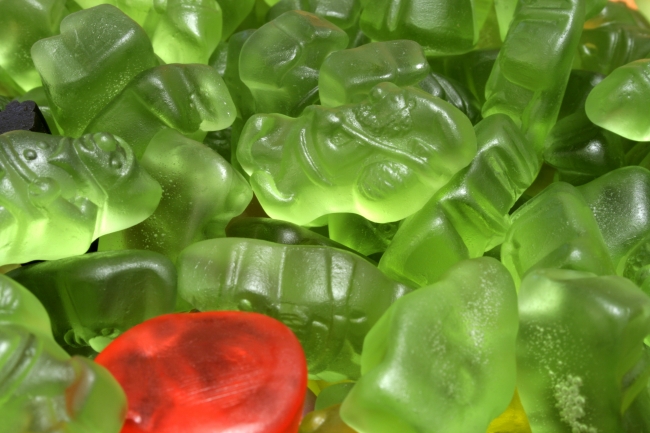 Green wine gum, Closeup of a bunch of green wine gum, gummi bears, one red and one black wine gum among them