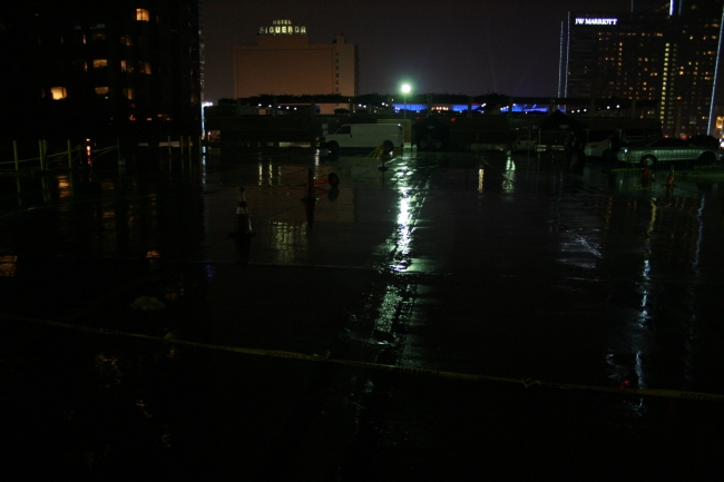 Wet parking lot near W 8th Street x S Figueroa St, at night, with the Figueroa Hotel and the JW Marriott in the distance