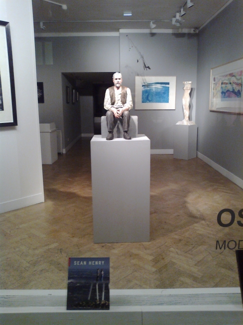 Man sitting on bloc, in a gallery's window