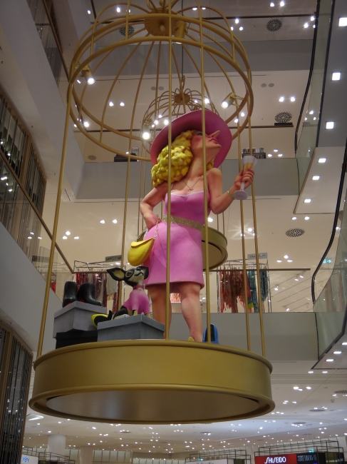 Lady in the cage, komische Skultpur bei Breuninger - ist der Shoppende Mensch eine karrikatur seiner selbst?