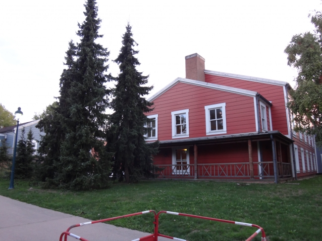 Red building and fir trees, 